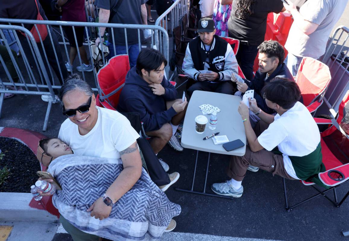 Fani Leilua holds her grandson Legend Leilua 2, at the front of the line for the grand opening ...