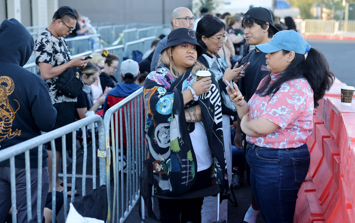 Tiffany Dela Cruz, left, and Peanut Dela Cruz, both of Las Vegas, wait near the front of the li ...