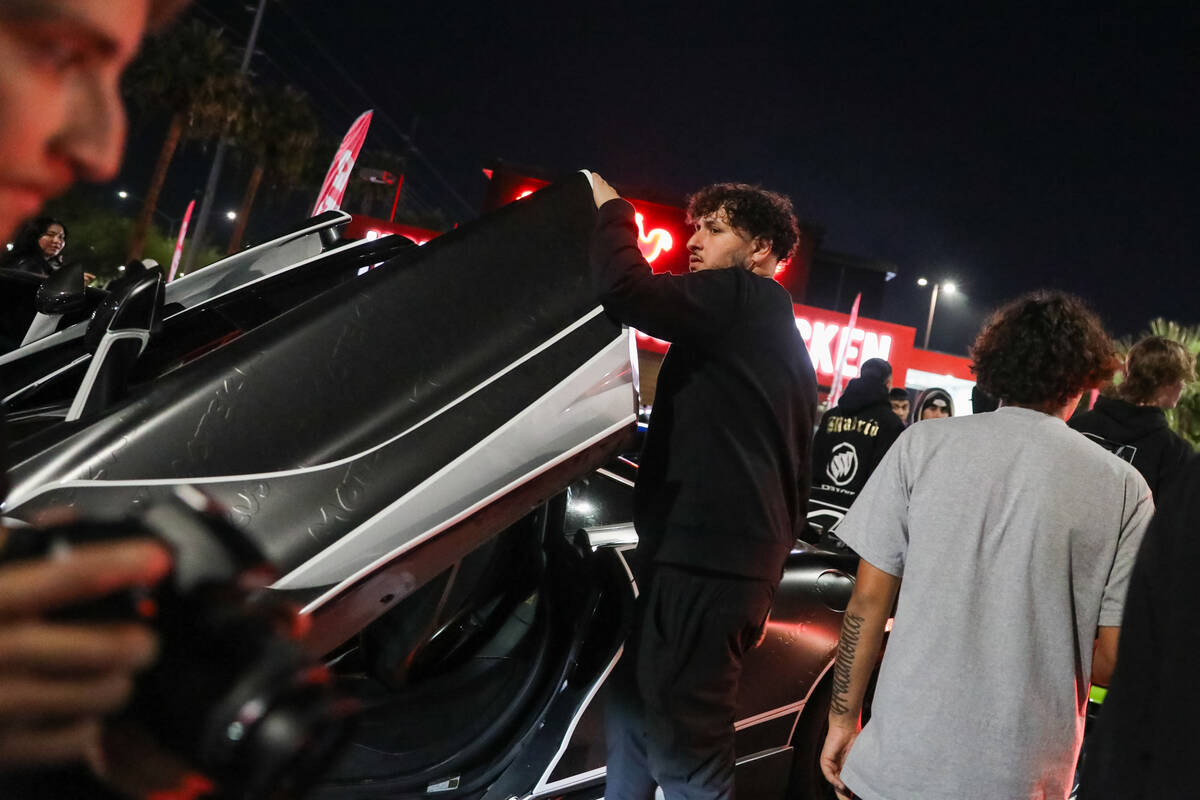 Sports car enthusiasts admire cars at The Vegas Meet car show, a separate SEMA event down the r ...