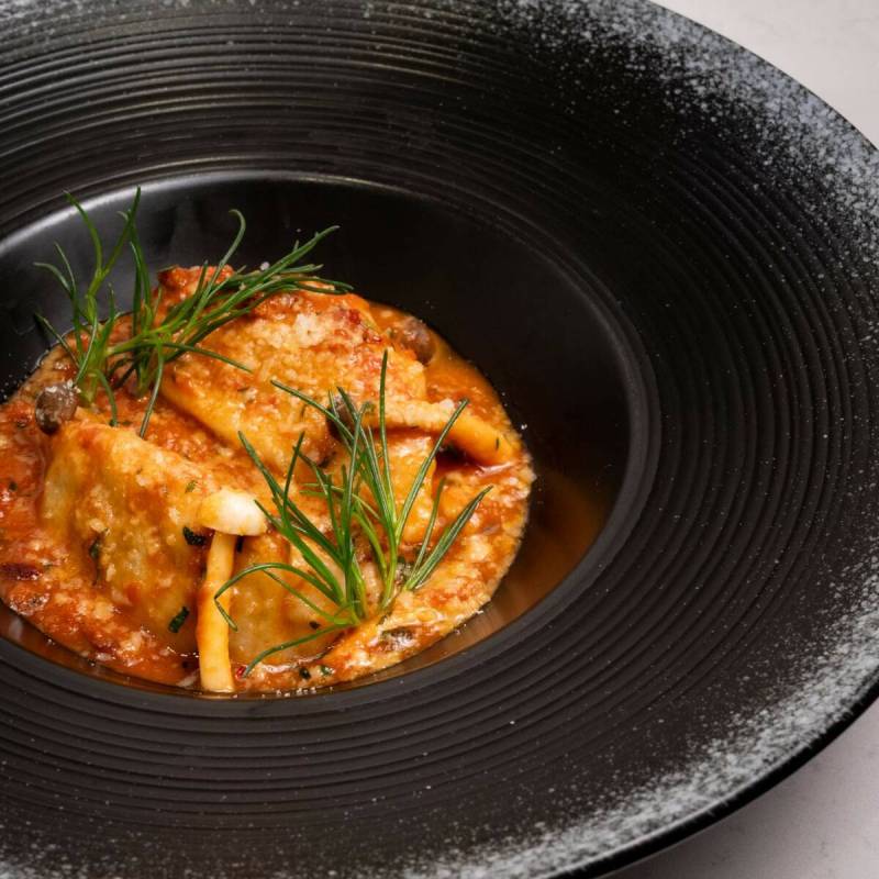 Crab culurgiones — crab-stuffed dumplings in lobster absinthe pomodoro — are on a seven-cou ...