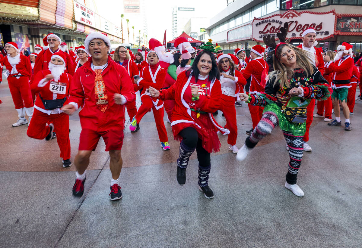 Left to right, Ron and Dale Endo and Kelly Harris dance with others during the pre-race enterta ...