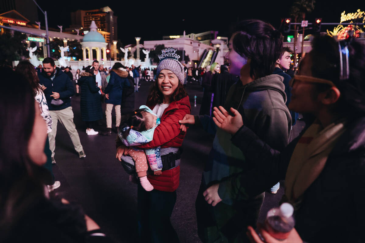 A sleeping child is held during New Year’s Eve celebrations on the Strip on Sunday, Dec. ...