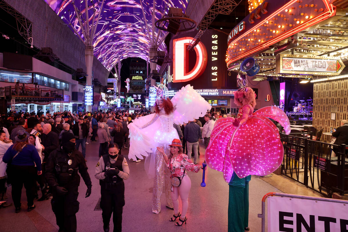 Norma Gallegos of Denver poses with stilt walkers Melanie Kramer, left, and Tida Siribongkot du ...