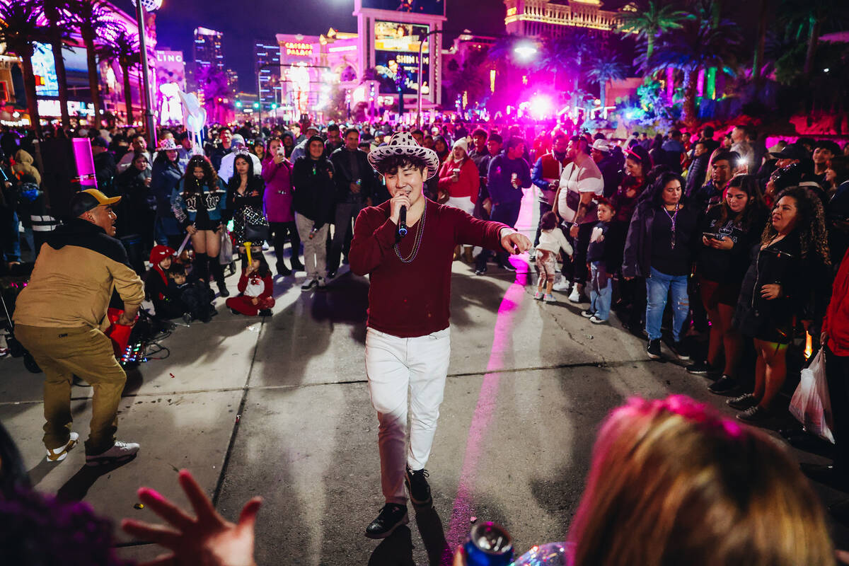 A busker performs for a crowd of New Year’s Eve revelers on Sunday, Dec. 31, 2023, in La ...