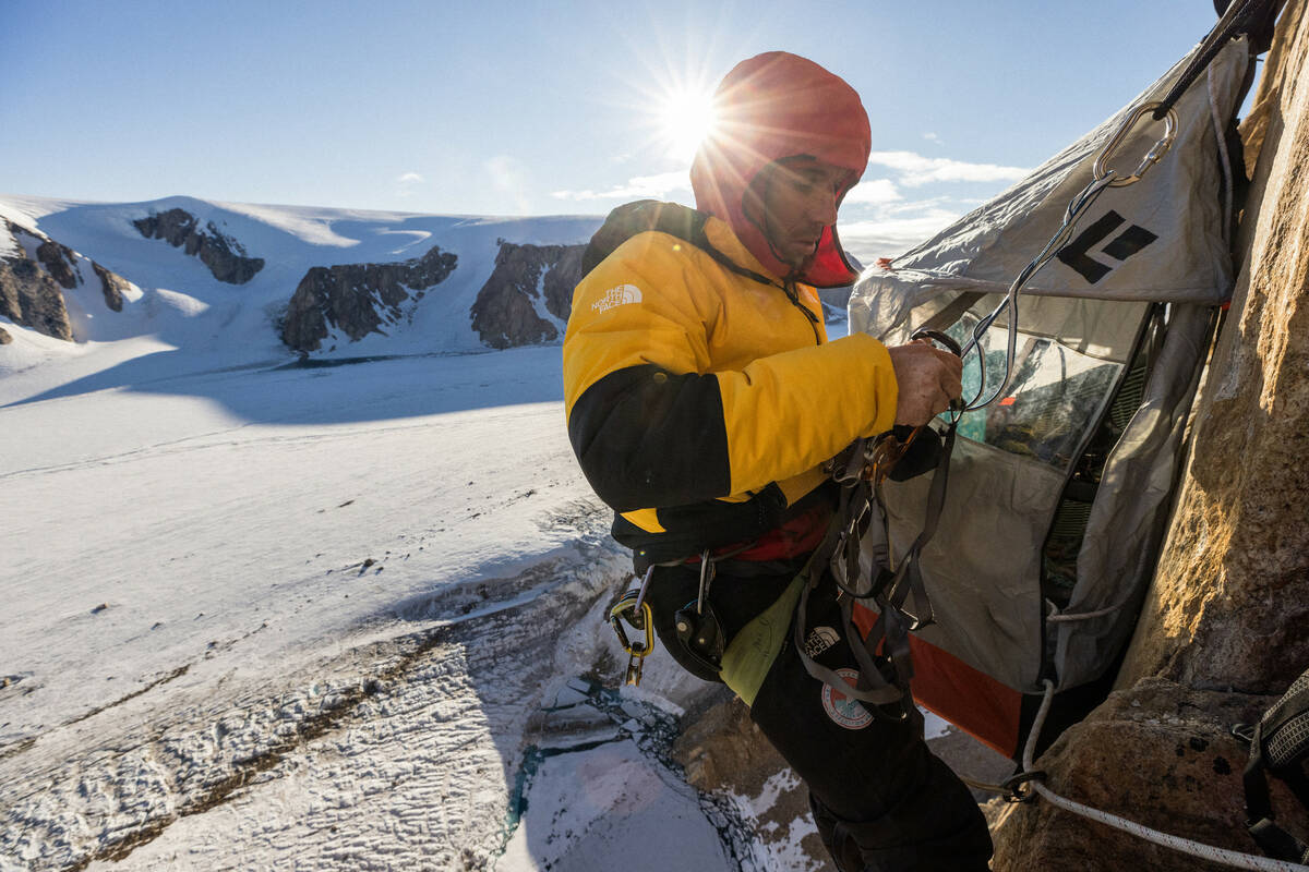 Alex Honnold checks his climbing harness and carabiners on Pool Wall in Eastern Greenland. (ph ...