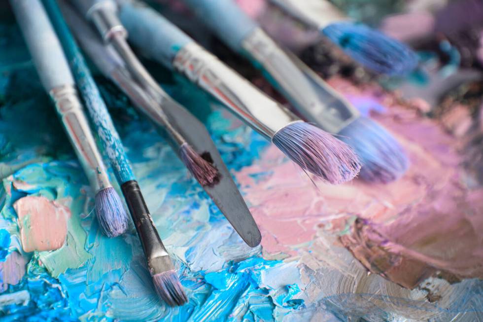 artists brushes and oil paints on wooden palette. macro artist's palette, texture mixed oil pai ...