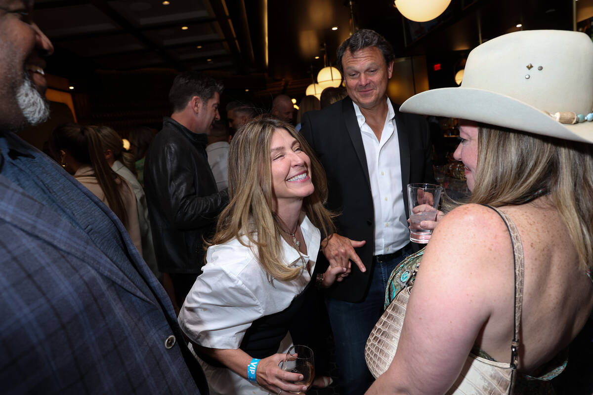 Partygoers dance at the bar during an opening night celebration at Emmitt's Vegas in Fashion Sh ...