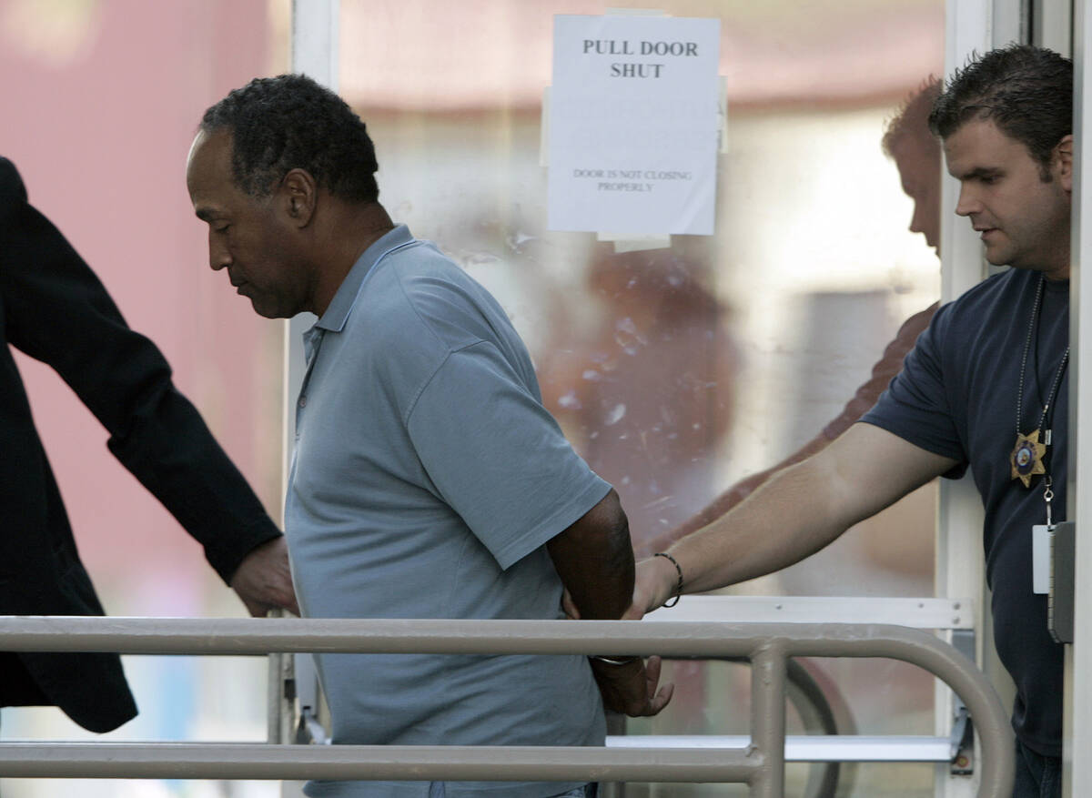 In this Sept. 16, 2007 file photo, O.J. Simpson is taken from the Las Vegas Police Investigativ ...