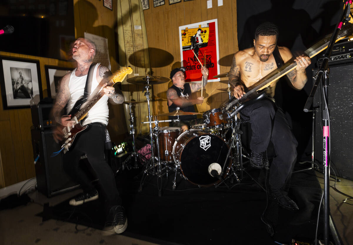 Tim Stewart, left, and Jonny Goood, of Damnage, right, perform with Branden Steineckert, of Ran ...
