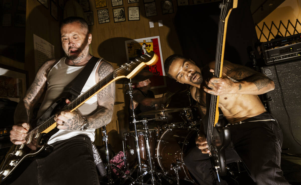 Tim Stewart, left, and Jonny Goood, of Damnage, right, perform with Branden Steineckert, of Ran ...