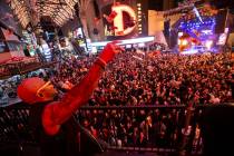 Flo Rida throws fake cash into the crowd while performing from a camera riser during the New Ye ...