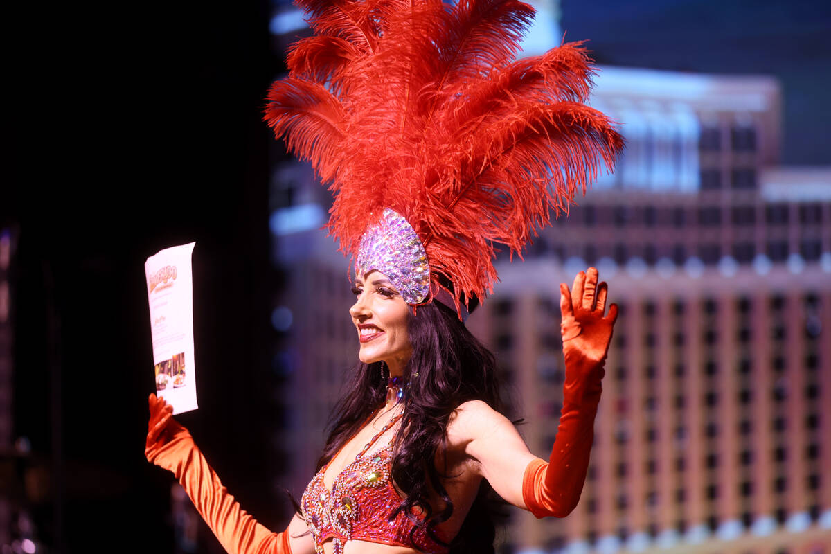 A showgirl displays a raffle prize during a taping of "The Dennis Bono Show" at the South Point ...