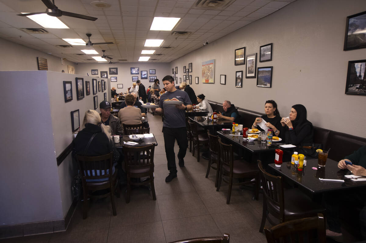 A waiter delivers food as people dine at Weiss Deli, soon to be Fisher’s Deli, on Thursd ...