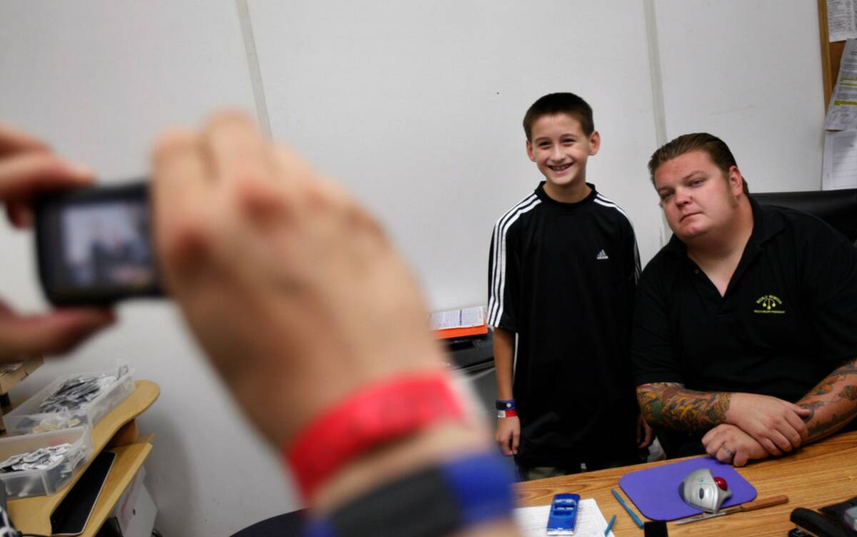 Andrew Rosas has his picture taken with Corey “Big Hoss” Harrison at Gold & Si ...