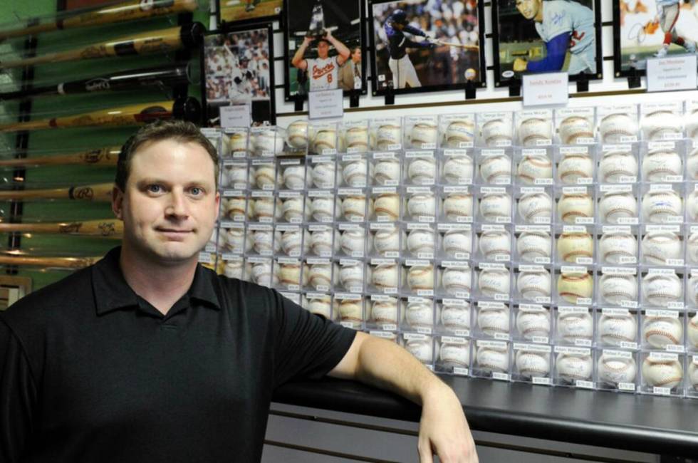 Jeremy Brown, owner of Ultimate Sports Cards & Memorabilia, poses for a portrait inside hi ...