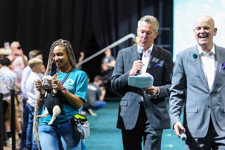 Volunteer Zuri Barlow carries Yoda next to hosts John Huck, center, and Chet Buchanan in the 20 ...