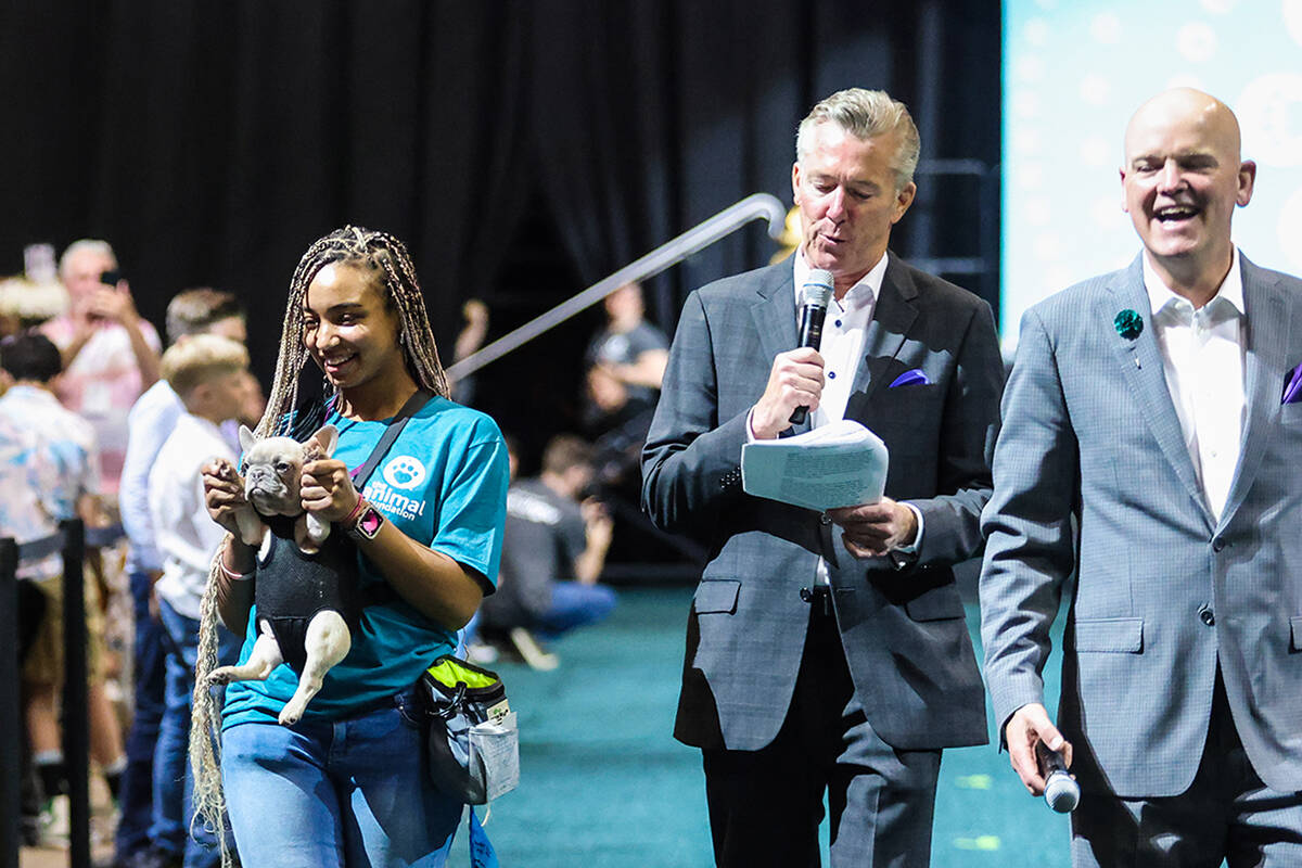 Volunteer Zuri Barlow carries Yoda next to hosts John Huck, center, and Chet Buchanan in the 20 ...
