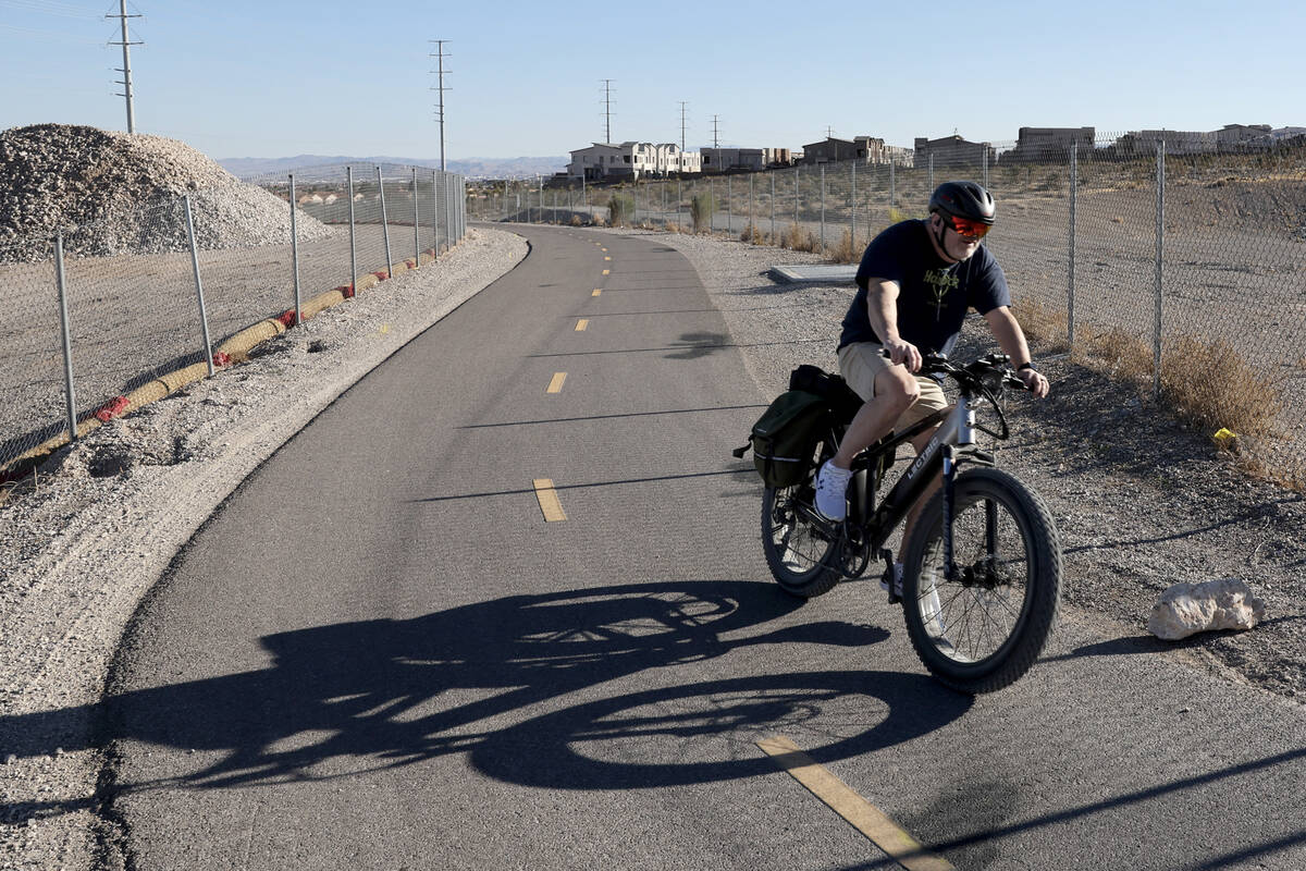 A cyclist rides an e-bike on the I-215 West Beltway Trail near Summerlin Parkway in Las Vegas T ...