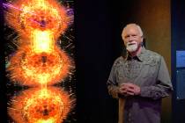 James Stanford stands next to his 10-foot-tall “Spectre Fission” art piece installed in “ ...