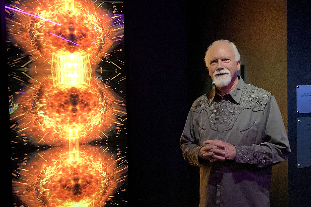James Stanford stands next to his 10-foot-tall “Spectre Fission” art piece installed in “ ...