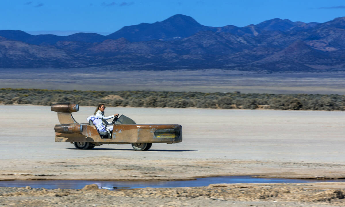 Melissa Ray and daughter Evie, 6, of Dallas move across the playa in a Sand Cruiser at Outpost ...