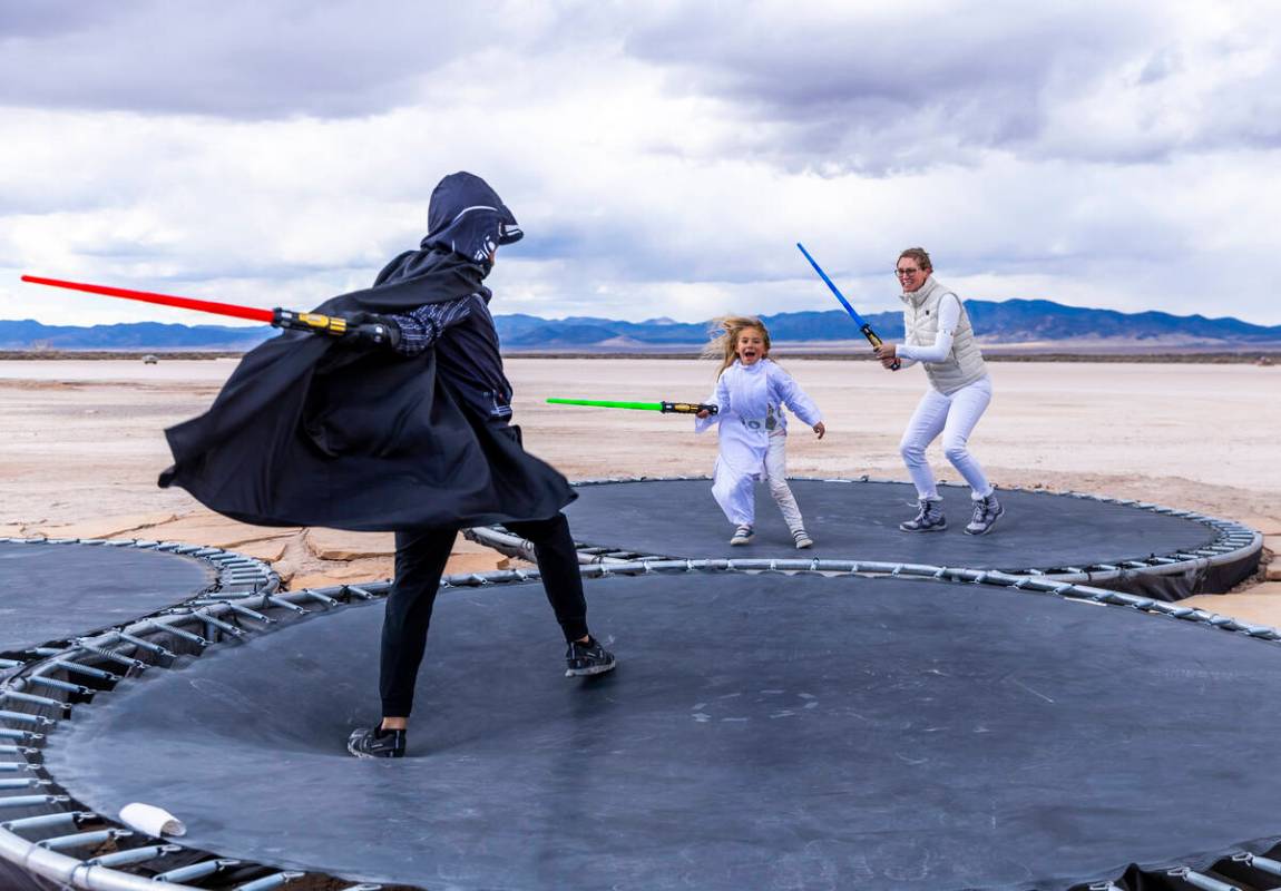 Barry Ray with daughter Evie, 6, and wife Melissa of Dallas, battle with light sabers atop of t ...