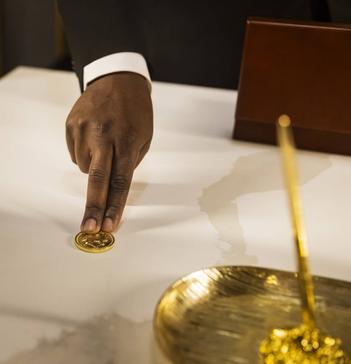 Byron Smith, a performer with the John Wick Experience, shows a gold coin in The Continental lo ...