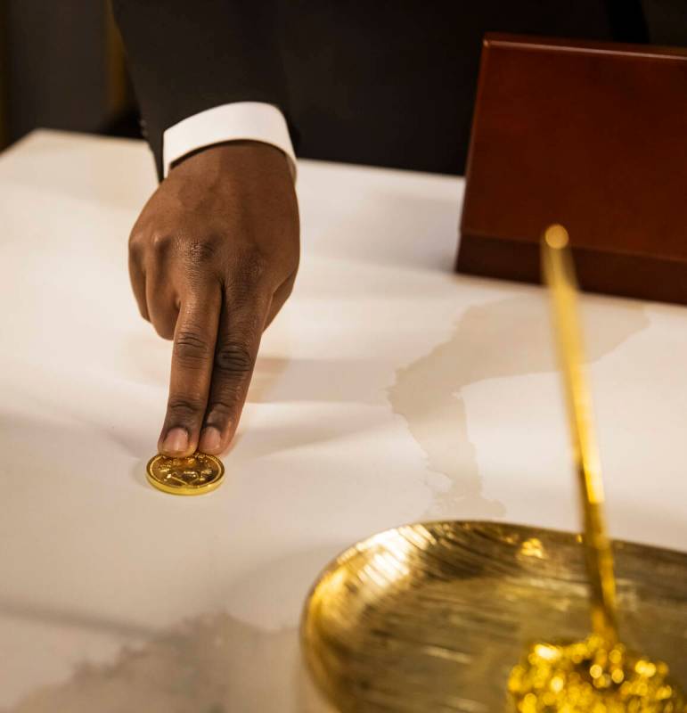 Byron Smith, a performer with the John Wick Experience, shows a gold coin in The Continental lo ...