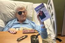 Norm Clarke holds a copy of his autobiography, “Power of the Patch,” in his hospice ...