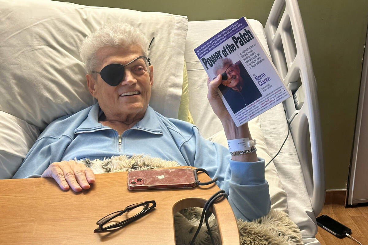 Norm Clarke holds a copy of his autobiography, “Power of the Patch,” in his hospice ...