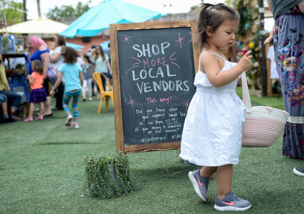 Kennedy Nguyen picks up an Easter egg she found on the ground at Market in the Alley on Sunday, ...