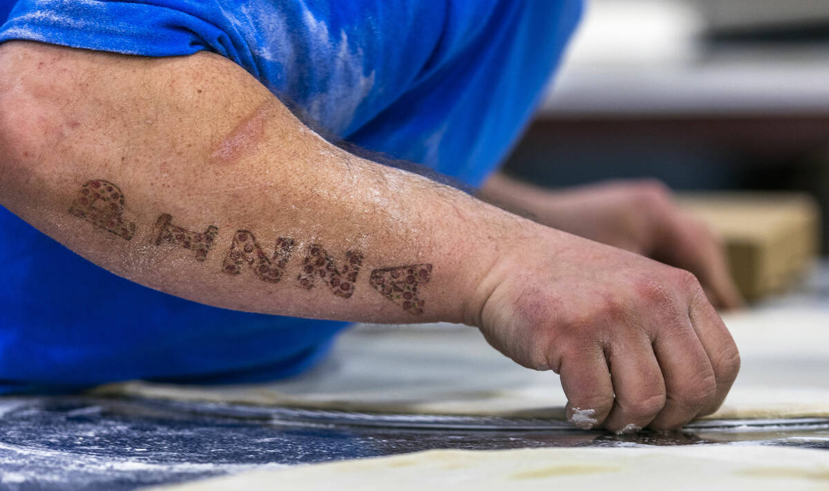 David Whisker with B.C. Pizza has the word pizza tattooed on his forearm while competing during ...