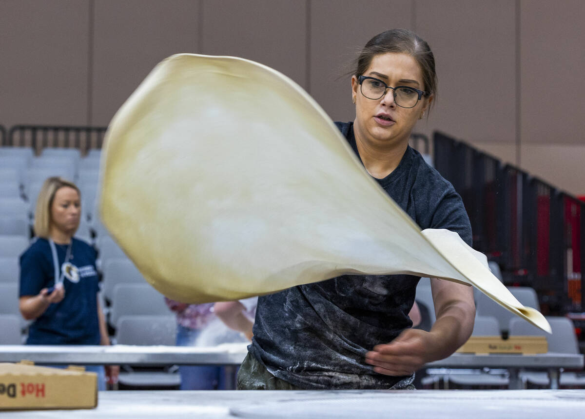 Competitor Tara Hattan with Andolini’s Pizzeria throws down her large pie dough during th ...