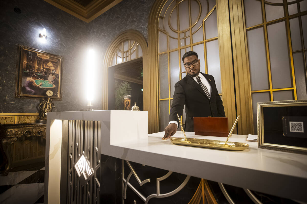 Byron Smith, a performer with the John Wick Experience, shows a gold coin in The Continental lo ...