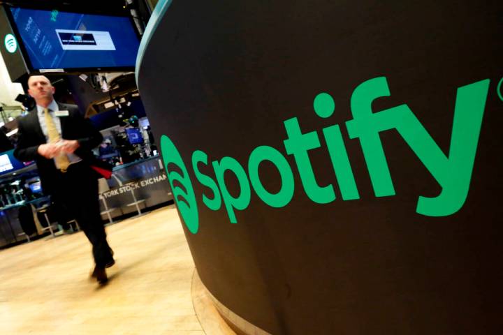 FILE – A trading post sports the Spotify logo on the floor of the New York Stock Exchange ...