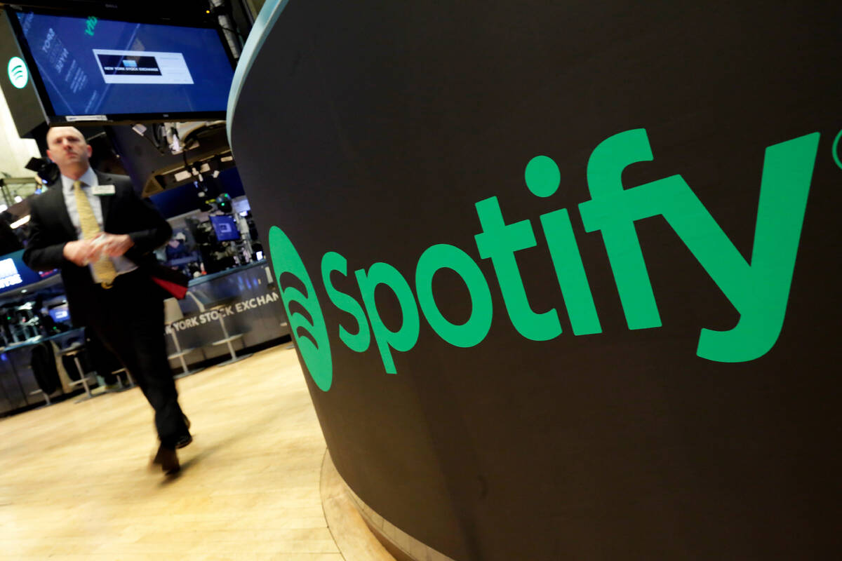 FILE – A trading post sports the Spotify logo on the floor of the New York Stock Exchange ...