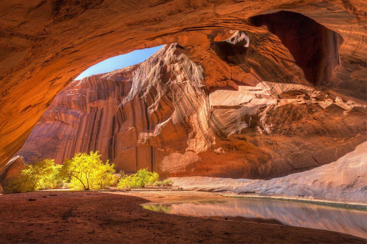 The red sandstone domed ceiling of Golden Cathedral in Neon Canyon has two arch potholes, with ...