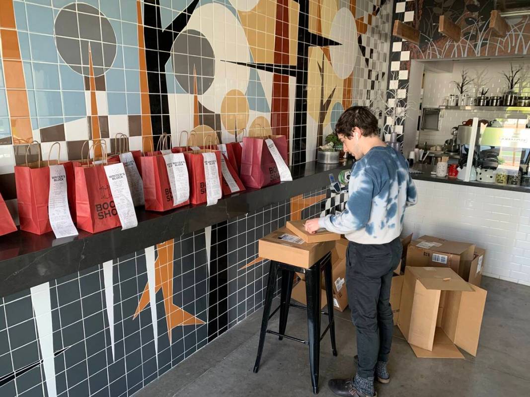 Drew Cohen packs and organizes online orders for shipping and curbside pickup at The Writer&#82 ...