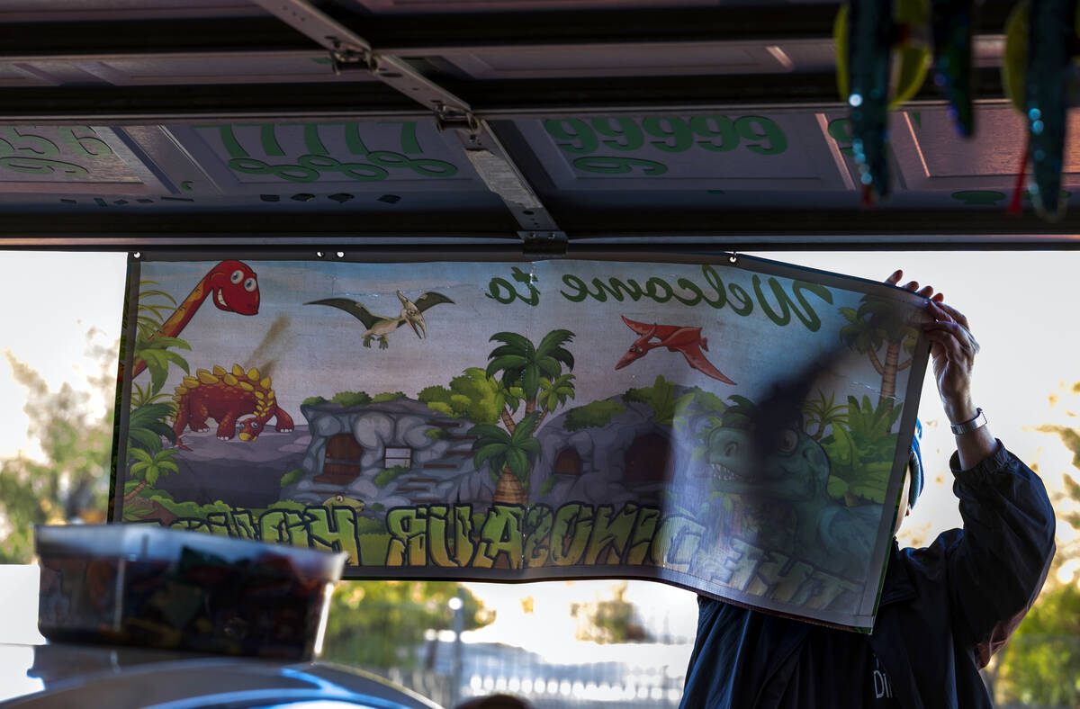 Former English teacher Steve Springer hangs his welcome banner as he opens his Shan-Gri-La Preh ...