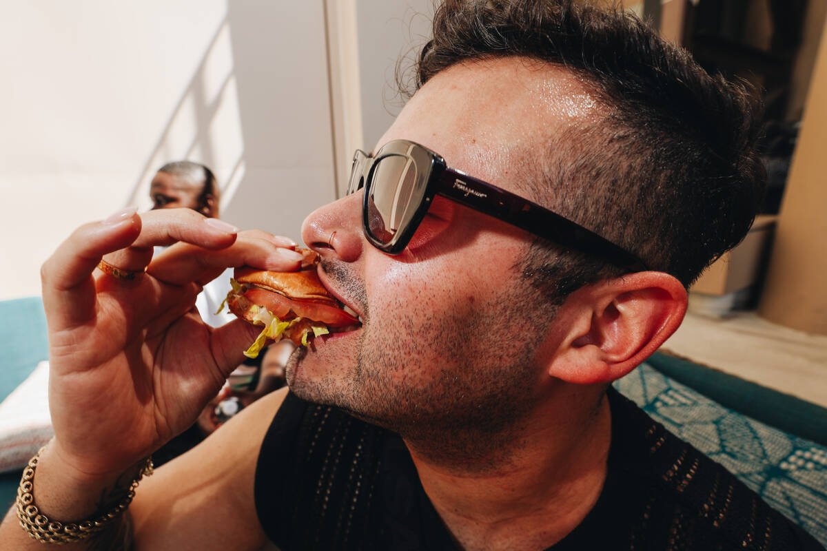Mo Perez enjoys a burger from Wahlburgers at AYU Dayclub at Resorts World Saturday, March 29, 2 ...