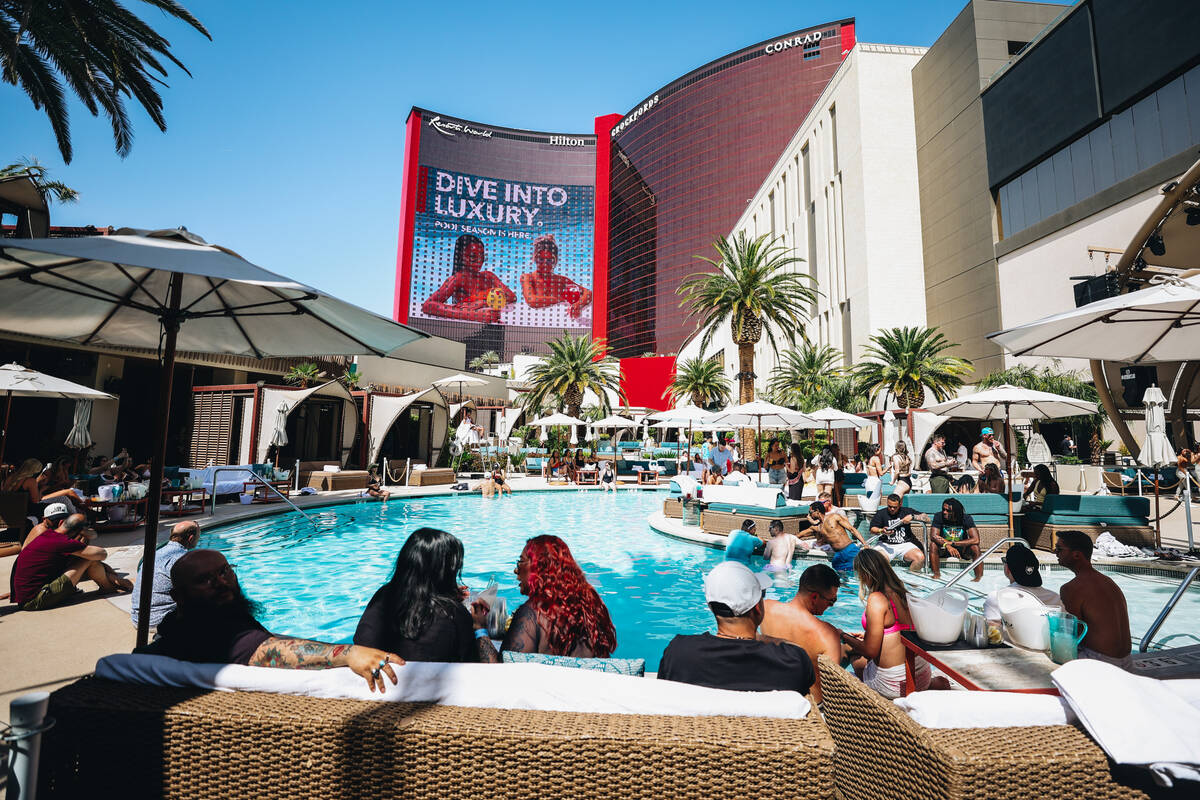 Club goers sit out by the pool at AYU Dayclub at Resorts World Saturday, March 29, 2025, in Las ...