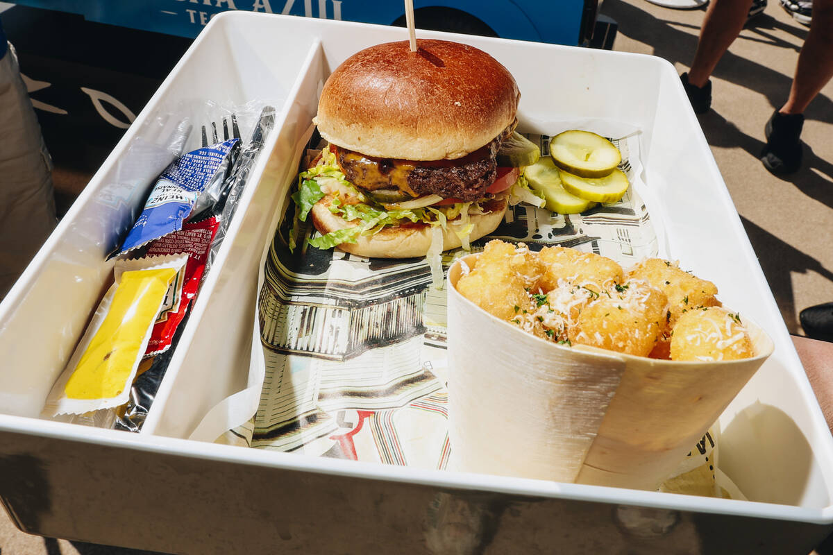 A Wahlburgers burger is brought out at AYU Dayclub at Resorts World Saturday, March 29, 2025, i ...