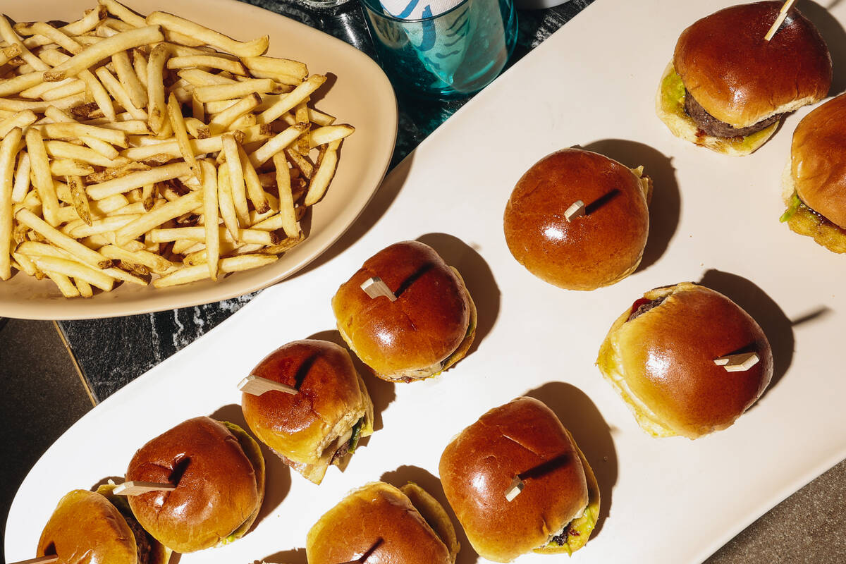 Slides and fries from Wahlburgers are laid out on a table at AYU Dayclub at Resorts World Satur ...