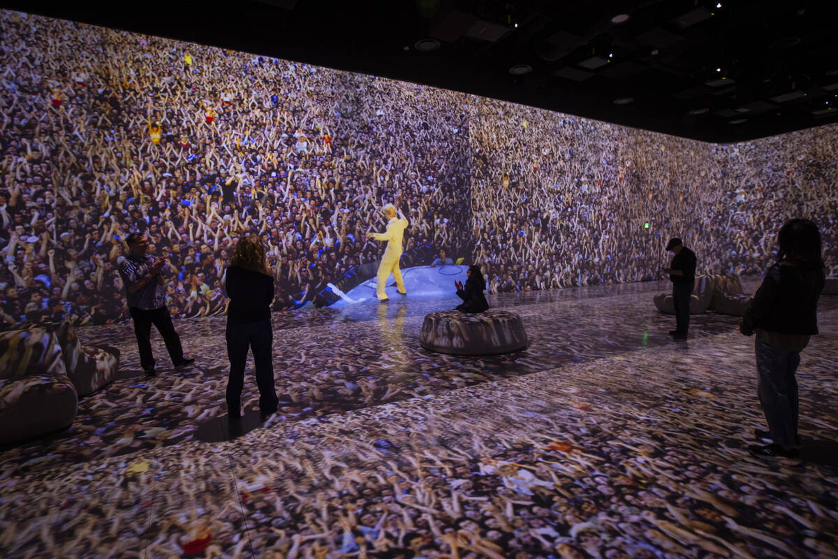 An image of David Bowie is displayed as people take in a preview of “Rolling Stone Prese ...