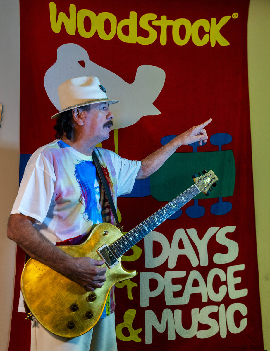 Carlos Santana plays his guitar in front of an Woodstock banner, he hoping to create a new conc ...