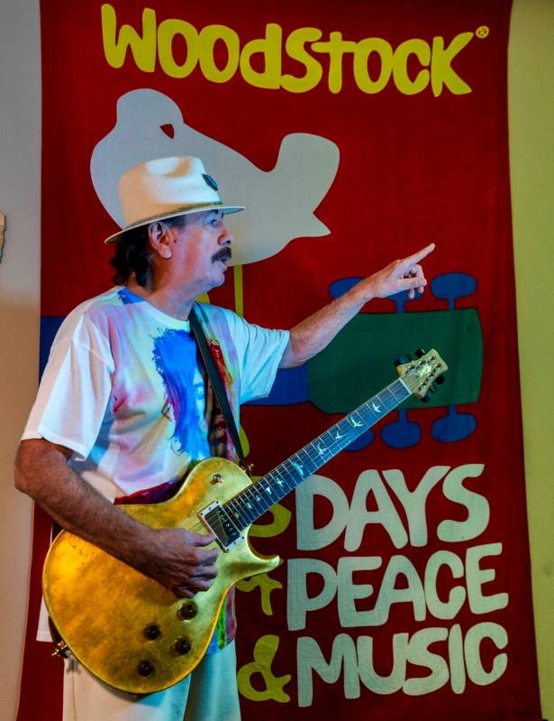 Carlos Santana plays his guitar in front of an Woodstock banner, he hoping to create a new conc ...