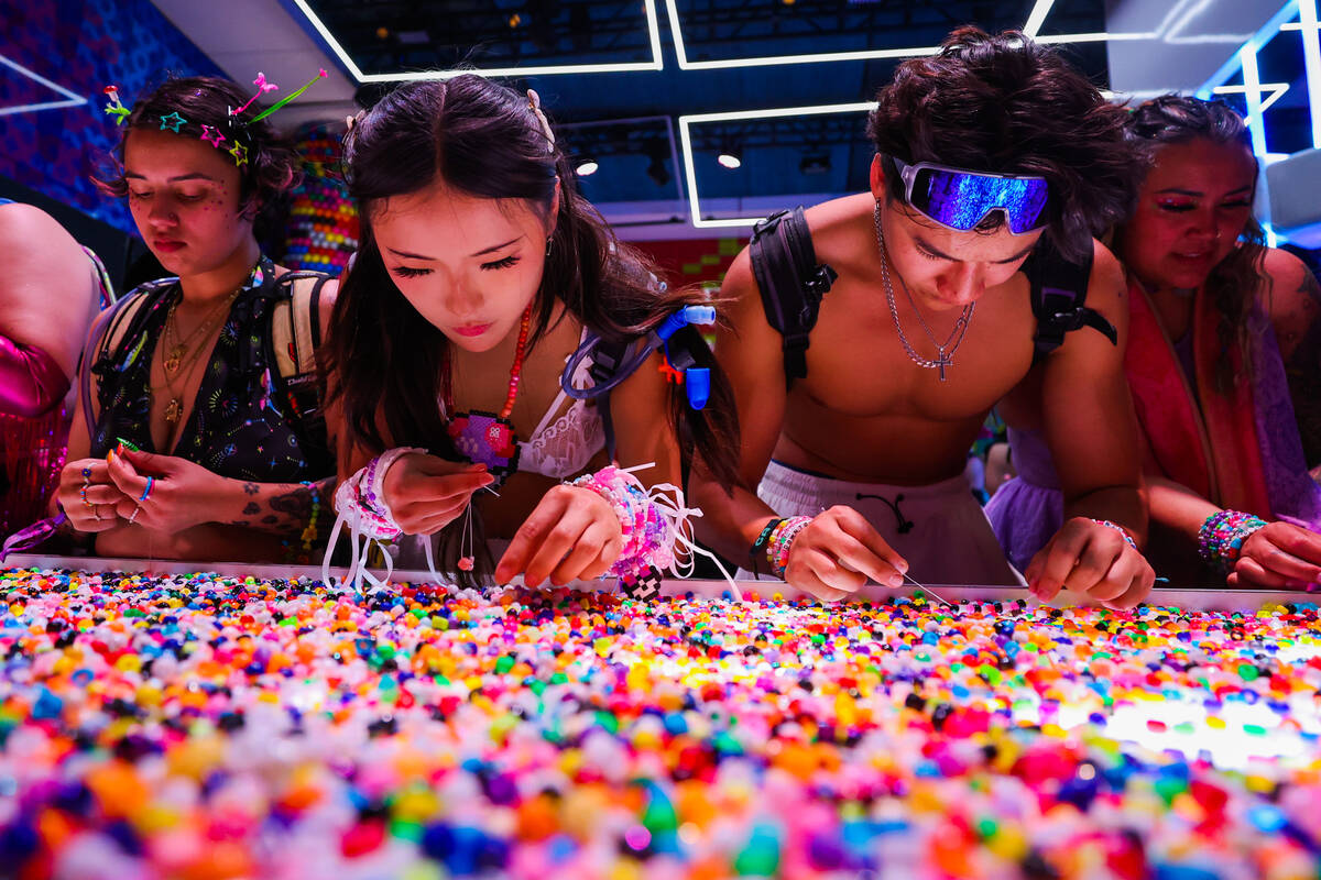 Festival attendees make kandi bracelets during day one of the Electric Daisy Carnival festival ...