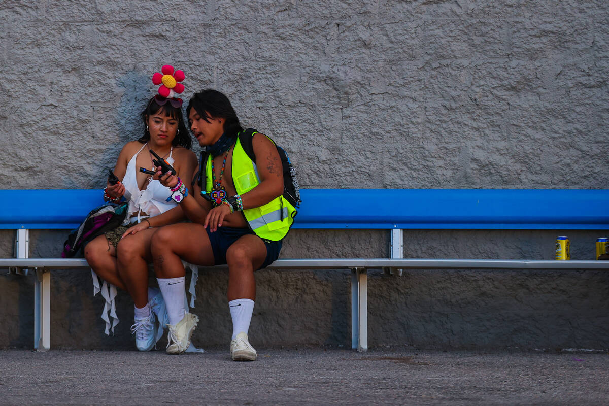Festival attendees sit on a bench during day one of the Electric Daisy Carnival festival at the ...