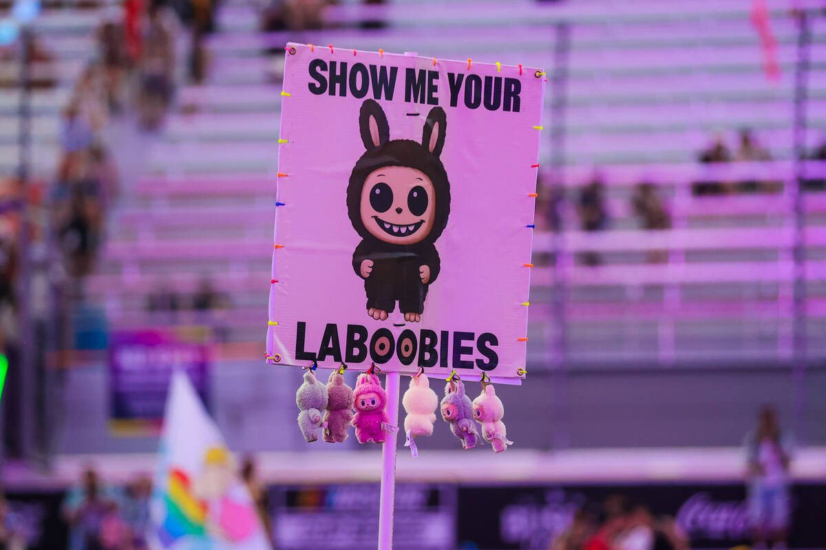 A sign with labubu dolls attached to it is held up during day one of the Electric Daisy Carniva ...