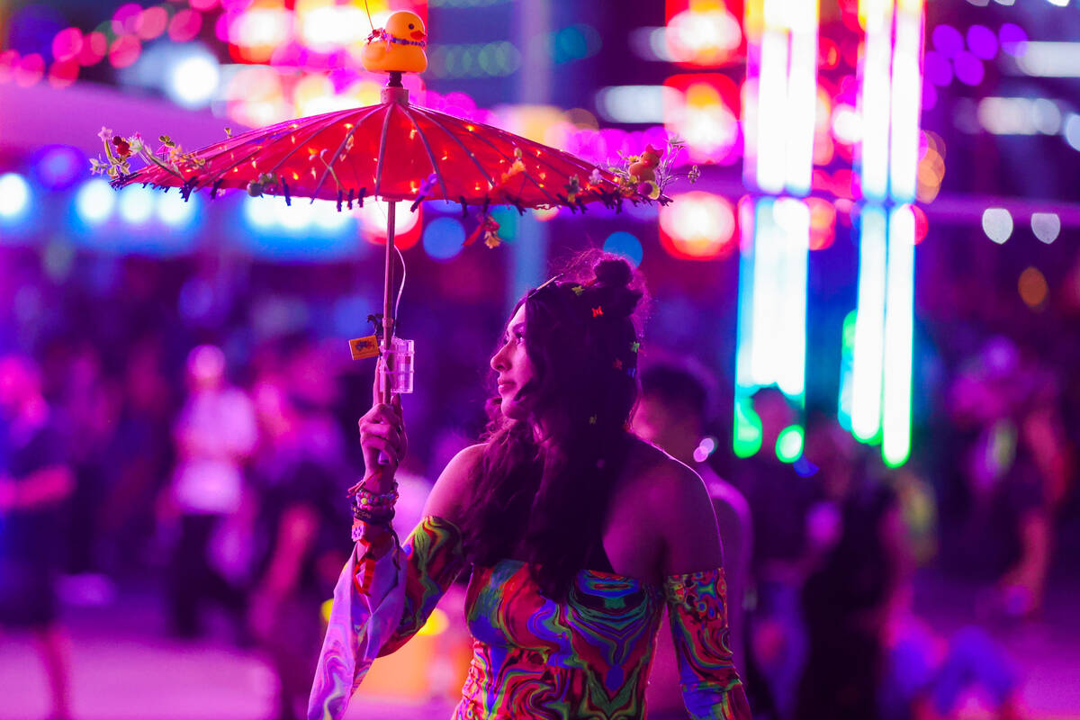A estival attendee holds up an umbrella during day one of the Electric Daisy Carnival festival ...